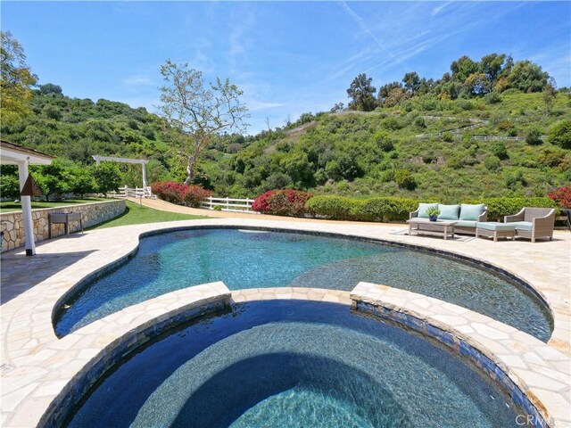 3 Poppy Trl, Rolling Hills, CA 90274 - view of pool featuring a pool with connected hot tub, an outdoor living space, a patio area, and a wooded view