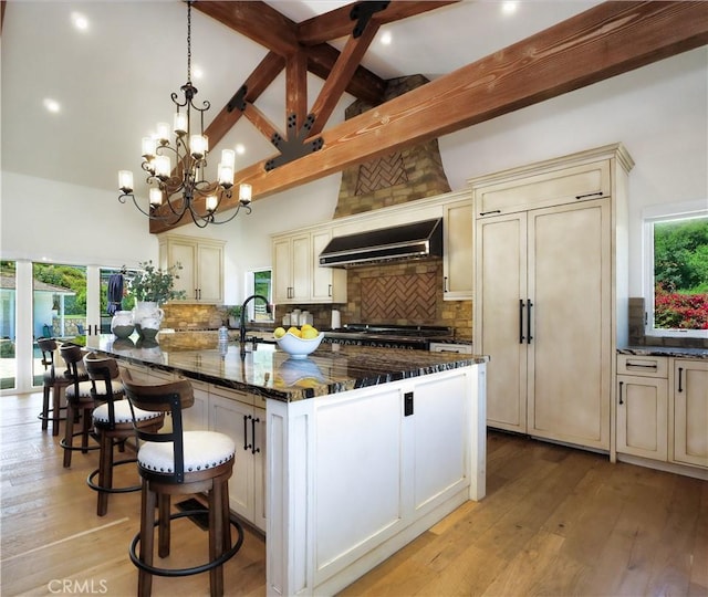 3 Poppy Trl, Rolling Hills, CA 90274 - kitchen with beam ceiling, custom exhaust hood, cream cabinetry, and dark stone countertops