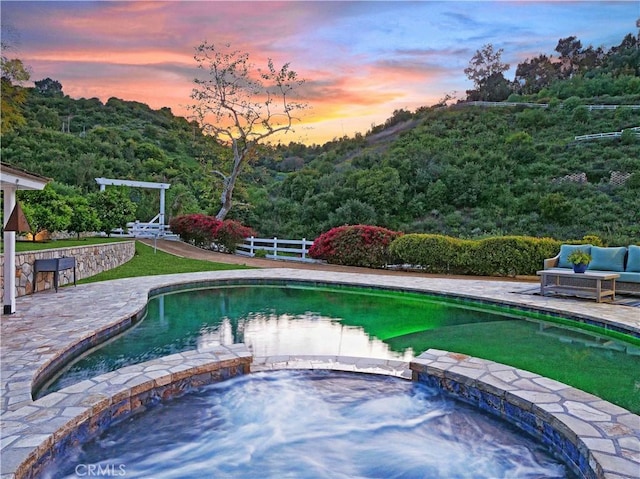 3 Poppy Trl, Rolling Hills, CA 90274 - pool at dusk with a forest view, a pool with connected hot tub, fence, and a patio area