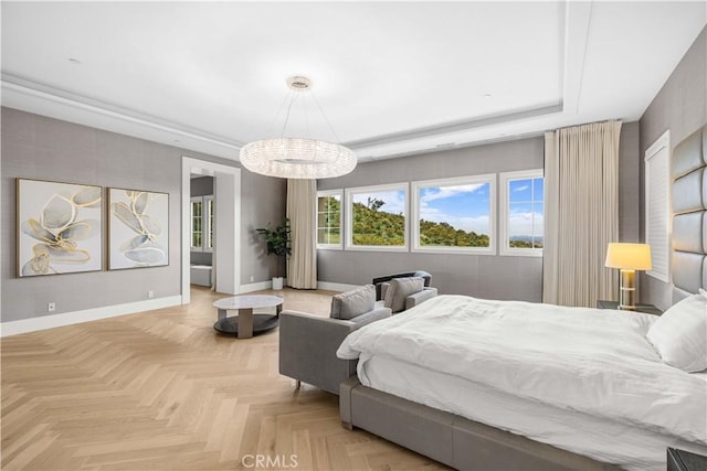 bedroom with baseboards, a raised ceiling, and a notable chandelier