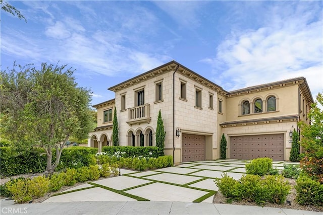 view of front of property with driveway, a balcony, and a garage