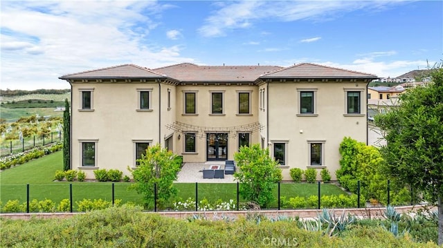 back of property featuring a yard, a patio area, stucco siding, and french doors
