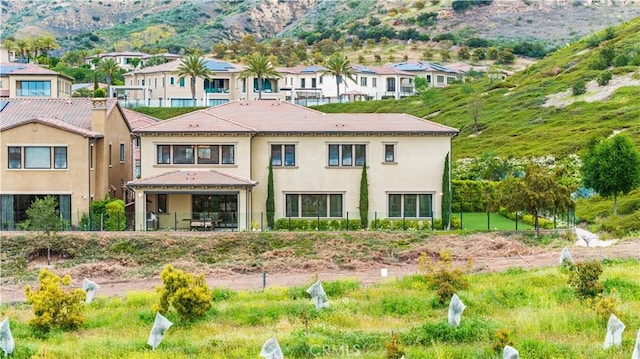 rear view of property featuring a mountain view and stucco siding