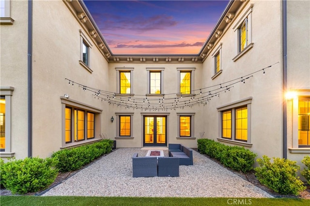 back of property featuring a patio, stucco siding, french doors, and an outdoor hangout area
