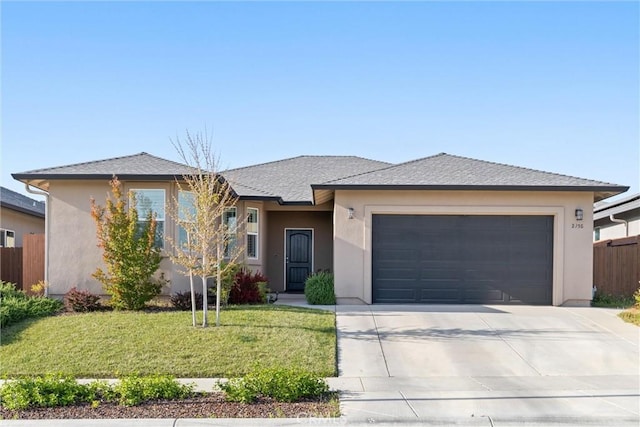 view of front facade with a front yard, stucco siding, concrete driveway, an attached garage, and fence