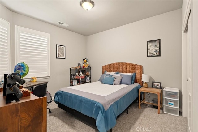 carpeted bedroom featuring visible vents