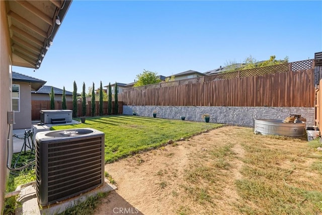 view of yard featuring central AC and a fenced backyard