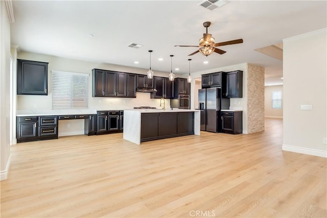 33827 Flora Springs St, Temecula, CA 92592 - kitchen featuring appliances with stainless steel finishes, light countertops, light wood-style flooring, a ceiling fan, and pendant lighting