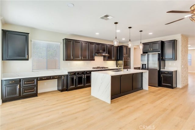 33827 Flora Springs St, Temecula, CA 92592 - kitchen with stainless steel appliances, a ceiling fan, light wood finished floors, decorative light fixtures, and recessed lighting