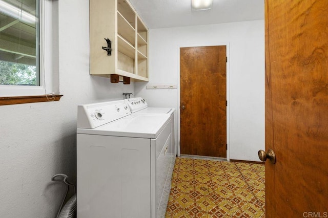washroom with tile patterned floors, washing machine and clothes dryer, and laundry area