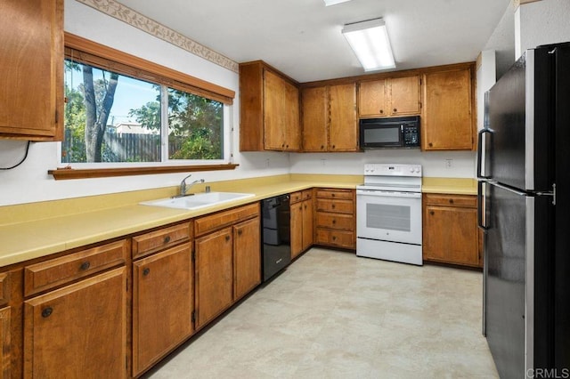 kitchen featuring black appliances, a sink, brown cabinetry, and light countertops