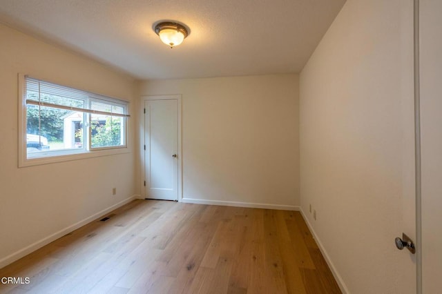empty room with light wood-style flooring and baseboards