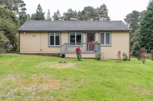 ranch-style home with a front yard and roof with shingles