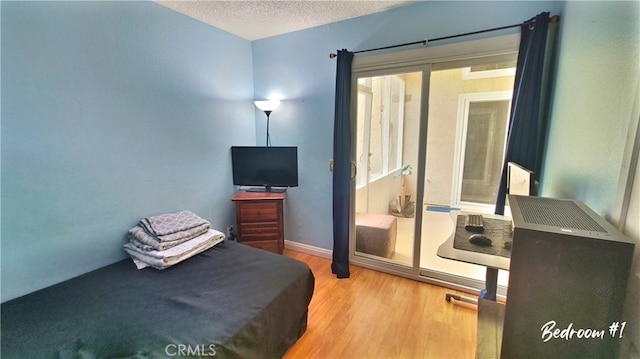 bedroom featuring a textured ceiling and wood finished floors