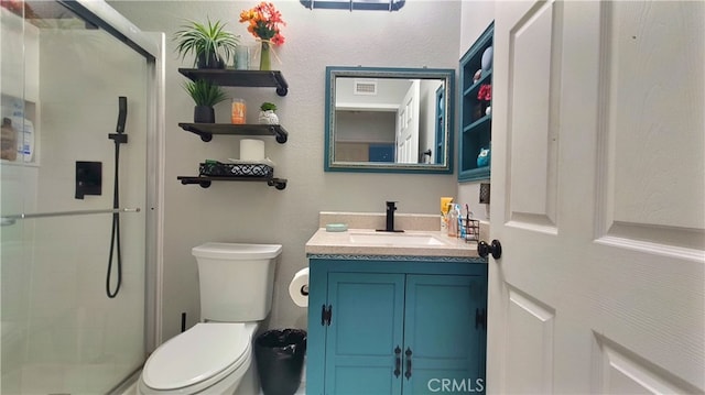 full bathroom featuring vanity, toilet, a shower stall, and visible vents