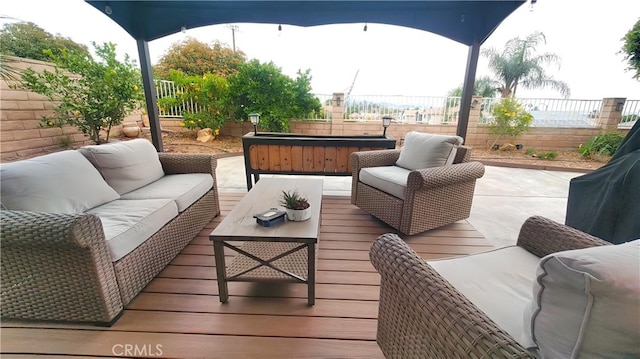 view of patio with a hot tub, a deck, a fenced backyard, and outdoor lounge area
