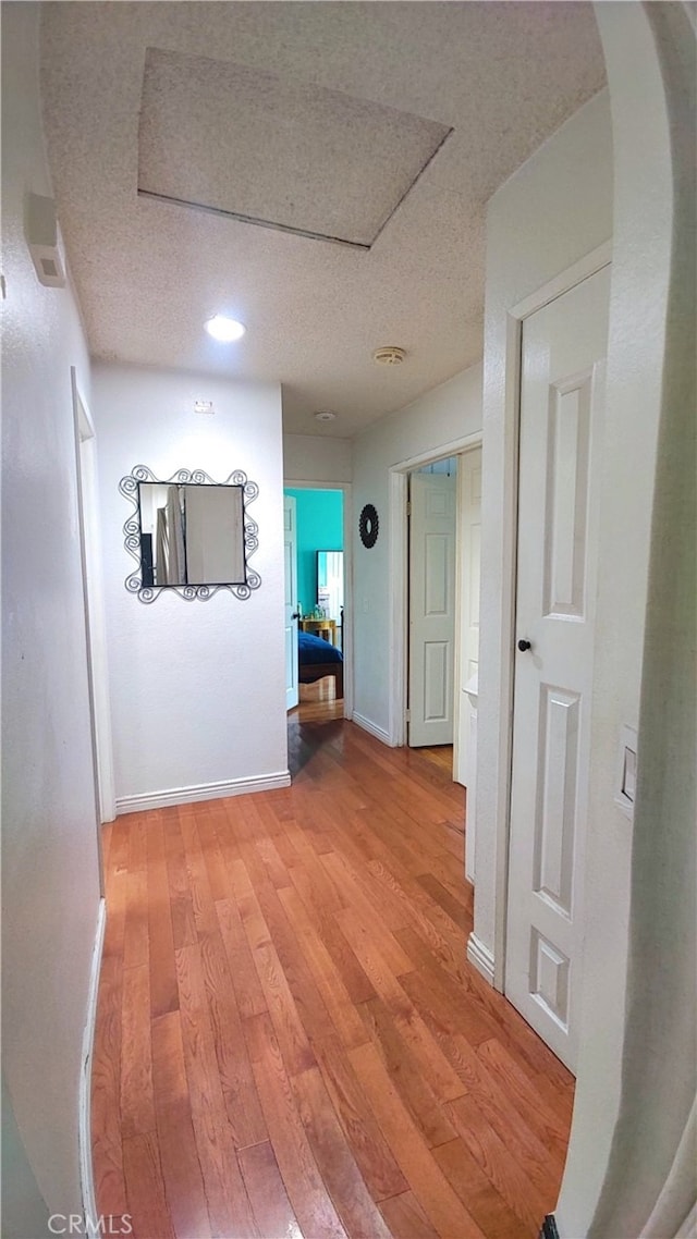 11622 Remington St, Sylmar, CA 91342 - hallway featuring a textured ceiling, light wood-style flooring, baseboards, arched walkways, and recessed lighting