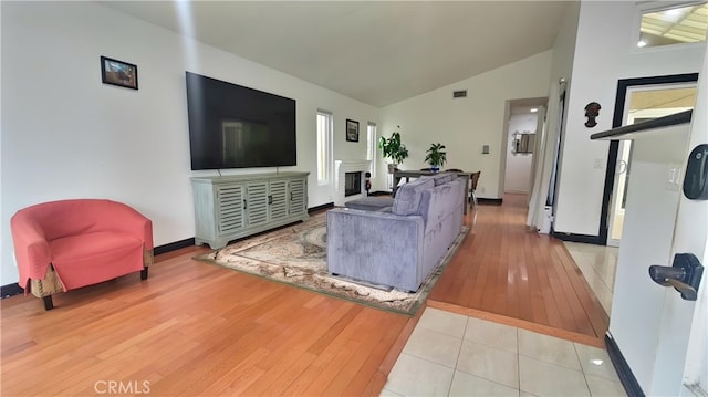 11622 Remington St, Sylmar, CA 91342 - living room featuring light wood-type flooring, baseboards, a fireplace, and high vaulted ceiling