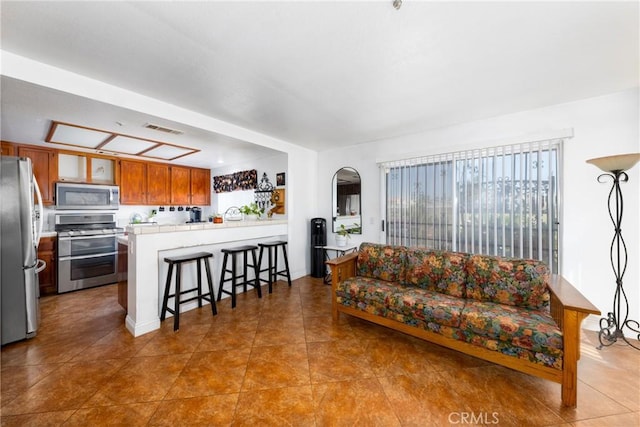 tiled living room featuring visible vents and arched walkways