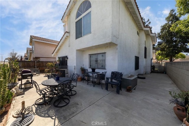 rear view of house featuring stucco siding, a patio area, and a fenced backyard