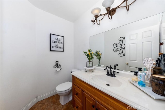 bathroom with toilet, tile patterned floors, vanity, and baseboards