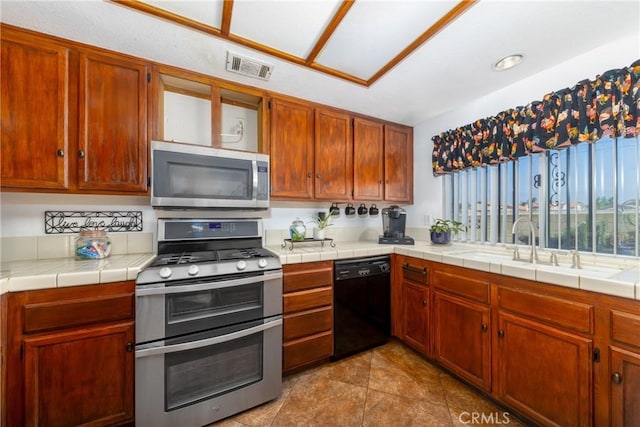 kitchen with a sink, tile patterned floors, visible vents, and stainless steel appliances