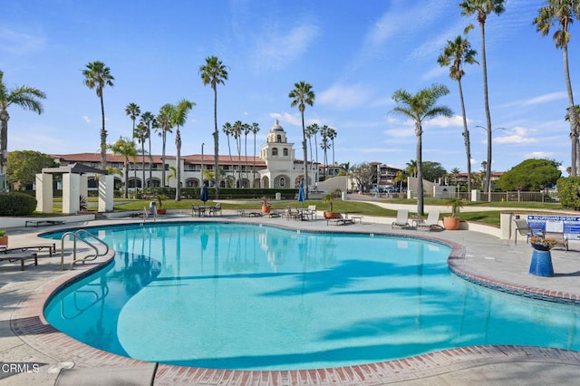community pool featuring a patio area and a yard