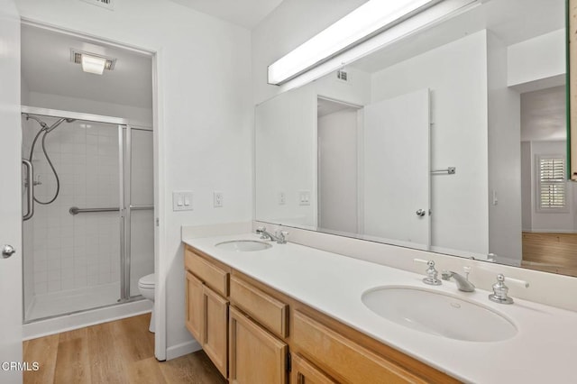 full bathroom featuring toilet, a stall shower, and a sink