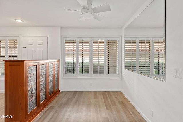 spare room with ceiling fan, wood finished floors, and baseboards