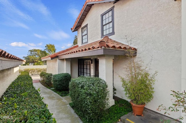 view of property exterior featuring stucco siding and a tile roof