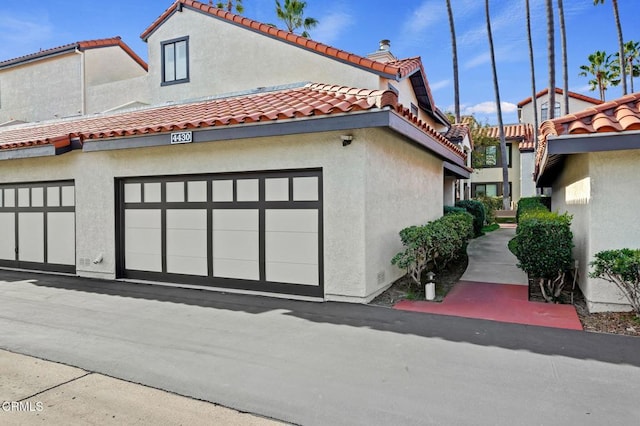view of side of property featuring stucco siding and a tile roof
