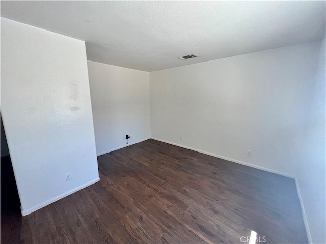 6476 Desert Knoll Ave Unit 29, Palms, CA 92277 - unfurnished room with baseboards, visible vents, and dark wood-type flooring