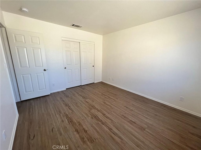 6476 Desert Knoll Ave Unit 29, Palms, CA 92277 - unfurnished bedroom with visible vents, a closet, dark wood-style floors, and baseboards