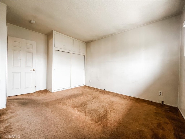 unfurnished bedroom featuring carpet floors and a closet