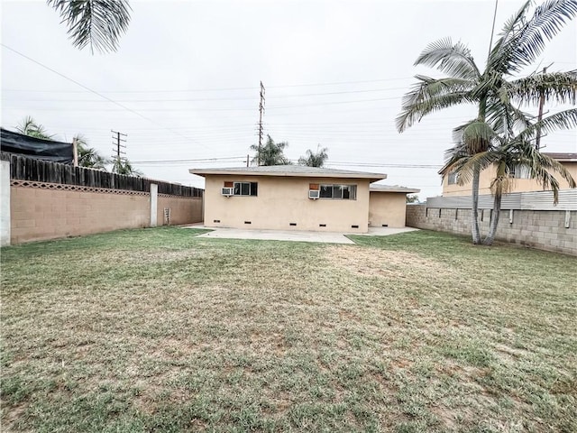 back of property with a fenced backyard, a patio, stucco siding, and crawl space