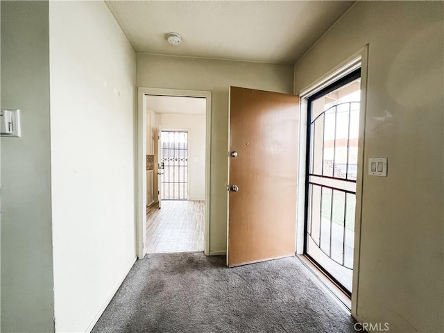 doorway featuring baseboards and carpet flooring