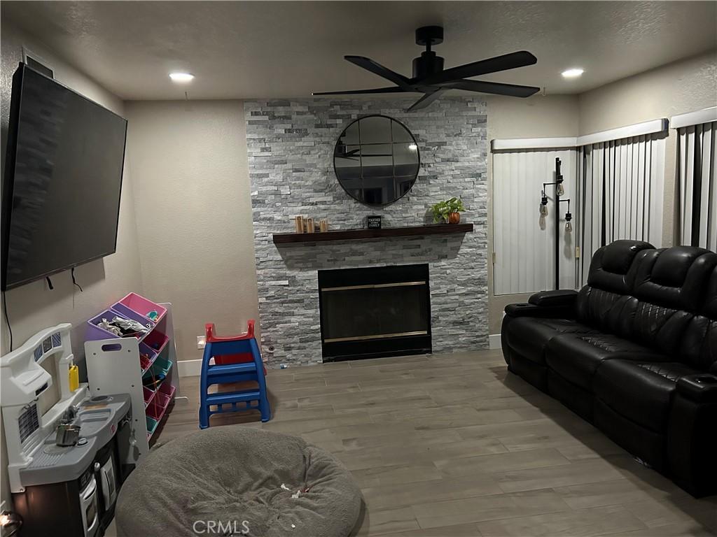 living room with a ceiling fan, recessed lighting, and a fireplace