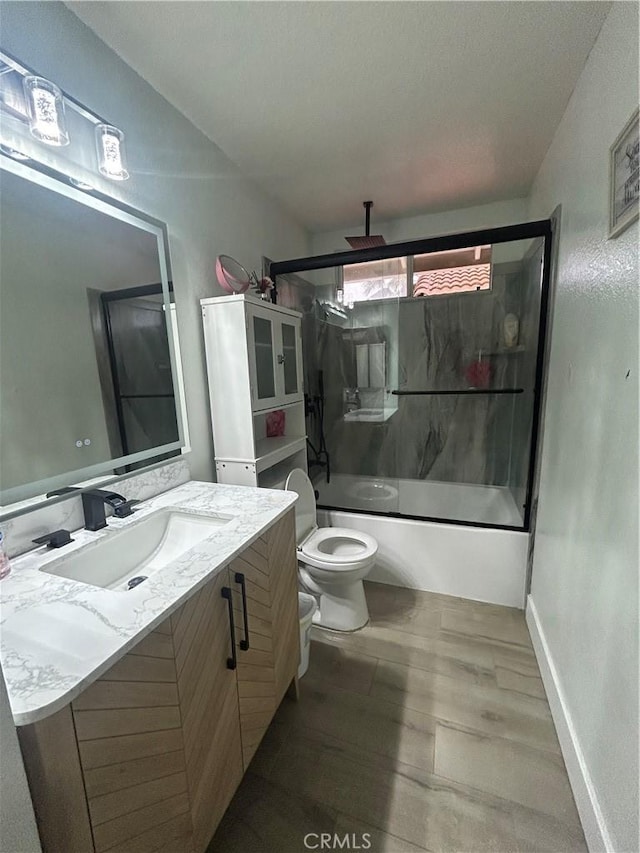 10075 Desert Mallow, Moreno Valley, CA 92557 - full bathroom featuring toilet, baseboards, bath / shower combo with glass door, vanity, and wood finished floors