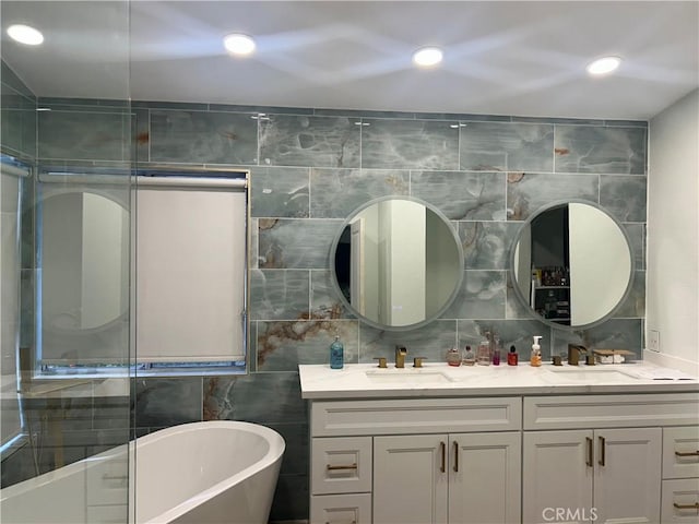 10075 Desert Mallow, Moreno Valley, CA 92557 - bathroom featuring tile walls, a freestanding tub, double vanity, and a sink