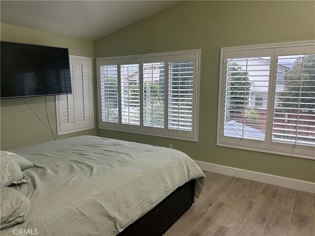 10075 Desert Mallow, Moreno Valley, CA 92557 - bedroom featuring multiple windows, vaulted ceiling, wood finished floors, and baseboards
