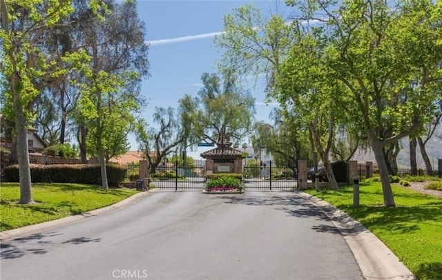 10075 Desert Mallow, Moreno Valley, CA 92557 - view of asphalt street featuring curbs, a gate, and a gated entry