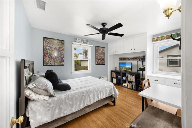 bedroom with visible vents, light wood-type flooring, and a ceiling fan