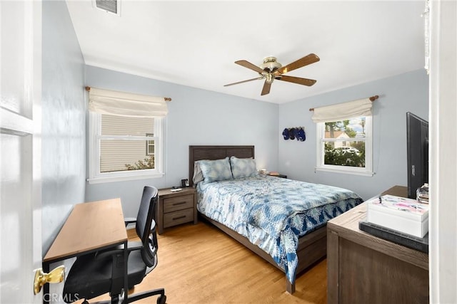 bedroom featuring visible vents, a ceiling fan, and light wood-style floors