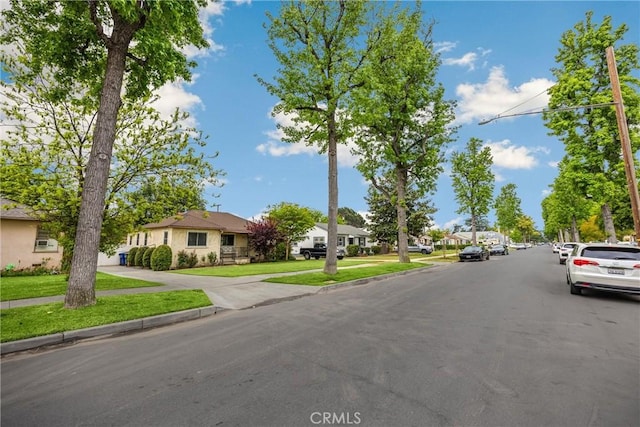 view of street featuring a residential view, sidewalks, and curbs