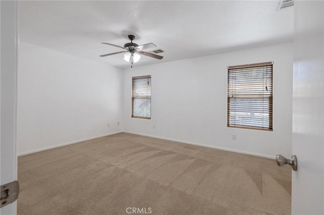 unfurnished room featuring baseboards, visible vents, a ceiling fan, and carpet floors