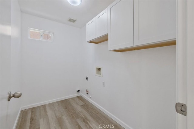 washroom featuring hookup for a washing machine, electric dryer hookup, cabinet space, light wood-style floors, and baseboards