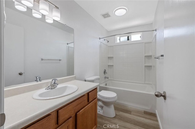 bathroom featuring visible vents, tub / shower combination, toilet, wood finished floors, and vanity