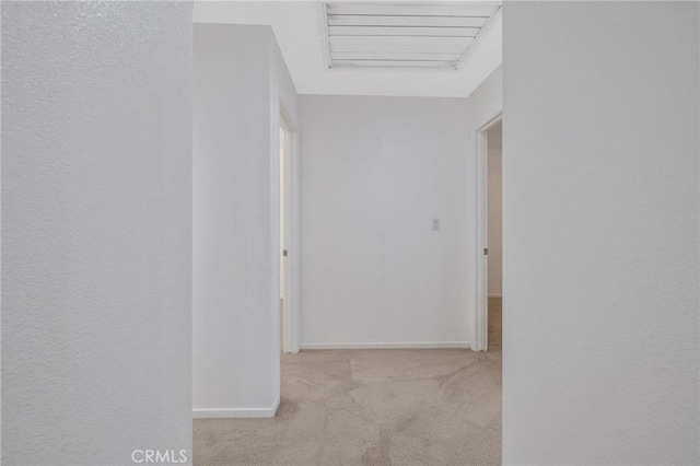 hallway with carpet flooring and baseboards
