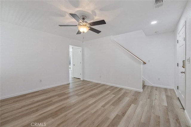 unfurnished living room with visible vents, a ceiling fan, stairs, and light wood-style flooring