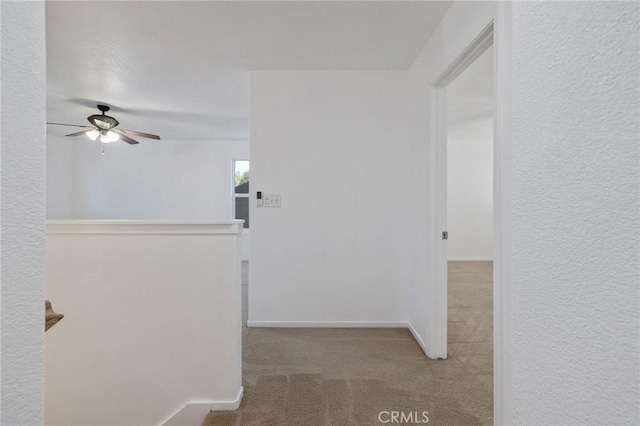 hall featuring baseboards and carpet